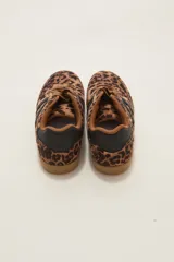 Zapatillas urbanas con estampado animal print de leopardo, cordones al tono y detalles de franjas laterales en color negro. Presentan suela de goma color caramelo y cuello acolchado.