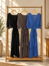Vestido midi de seda italiana color marrón, con escote en V, mangas murciélago holgadas y falda en capas con volados. Cuenta con cintura elastizada y lazo ajustable al tono.