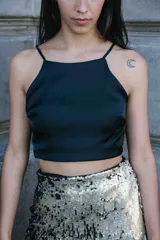 Top corto de satén negro con escote recto y breteles finos.