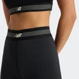 Calza corta deportiva New Balance, color negro, con cintura elástica de tiro alto que presenta la insignia de la marca. Confeccionada con tecnología NB DRY de secado rápido y tejido elástico para mayor libertad de movimiento.