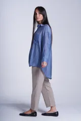 Camisa negra de tela traslúcida con cuello clásico, cierre frontal con botones y dos bolsillos de parche en el pecho.