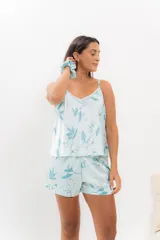 Pijama de seda estampada con diseño floral en tonos celestes y blancos. Incluye una musculosa con escote en V y espalda recta, y un short con elástico en la cintura.