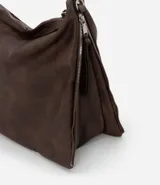 Bolso hobo grande desestructurado color marrón oscuro, con correa de mano y correa larga desmontable. Presenta cierres laterales ajustables con tiradores y cierre superior.