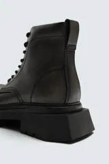 Bota tipo derby con cordones, confeccionada con acabado efecto desgastado. Presenta horma redonda y suela gruesa con diseño track.