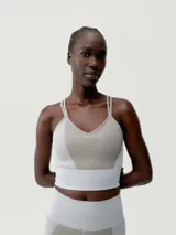 Top deportivo color gris con textura acanalada, tirantes finos y logo en el frente.