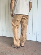 Pantalón de lino color camel, de corte ancho y relajado, con cintura elastizada y cordón ajustable.