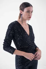 Mono largo negro con lentejuelas, escote en V cruzado, mangas largas y corte ajustado.