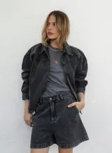 Campera de denim color negro con efecto lavado, corte semi oversize, cierre frontal completo, cuello camisero y bolsillos laterales.