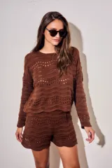 Sweater oversize de tejido de punto color blanco con diseño calado de ondas y cuello redondo, de manga larga.