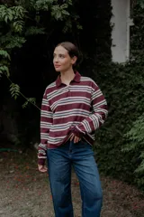 Buzo de manga larga con cuello polo y botones, estampado a rayas horizontales en colores bordó, blanco, beige y celeste.