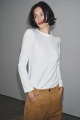 Camiseta de manga larga confeccionada en tejido de punto interlock elástico y flexible, con cuello redondo y bajo recto.