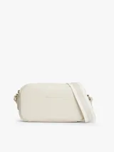 Cartera tipo bandolera de diseño compacto y líneas redondeadas, marca Tommy Hilfiger. Está confeccionada en poliuretano con acabado liso de color beige, cierre de cremallera y cuenta con una inscripción de la marca en bajo relieve en la parte delantera. Incluye una correa cruzada ajustable de jacquard tonal con el logo de la marca.