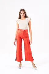 Pantalón wide leg color rojo metalizado, de tiro medio y corte ancho con aberturas laterales en el ruedo.