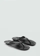 Sandalia negra plana con detalle de tachas plateadas.