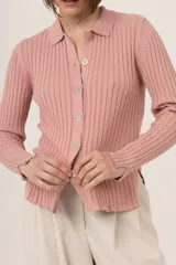 Camisa azul de punto 100% algodón con cuello polo, manga larga y cierre frontal con botones.