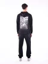 Hoodie negro con capucha y bolsillo canguro. Presenta un pequeño texto estampado en blanco en el pecho que dice: "STREET STYLE HAS REVOLUTIONIZED THE FASHION INDUSTRY".