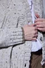 Saco de paño gris de corte recto y largo, con solapas clásicas y forro interior oscuro.