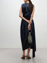 Falda midi azul marino de acetato, corte tubo, con frunces laterales, abertura diagonal y cintura elástica.