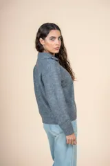 Cárdigan gris de tejido de punto acanalado, con cuello alto, cierre de cremallera corto y corte holgado.