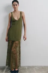 Vestido midi de punto acanalado color verde oliva, con escote en V y tirantes anchos. La parte superior presenta un diseño de tejido rib, mientras que la parte inferior está terminada con una aplicación de encaje transparente al tono.