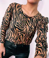 Remera de manga larga con cuello redondo y estampado de cebra en colores verde, rojo, azul y marrón.