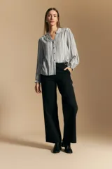 Camisa de manga larga con silueta relajada, estampado a rayas verticales en blanco y gris, escote abierto con botones frontales y puños elastizados.