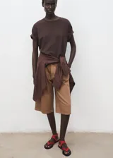 Short de gabardina marrón de tiro medio, diseño recto tipo bermuda, con pinzas en la parte delantera, bolsillos laterales y cinturón ajustable incorporado.