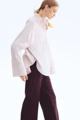 Pantalón de vestir color borgoña oscuro, de corte bootcut con raya marcada en el frente y la espalda. Presenta pretina prolongada con cierre oculto y bolsillos al bies y ribeteados en la parte trasera.