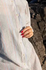Vestido midi rayado con mangas abullonadas, botones frontales y aberturas laterales en el dobladillo.
