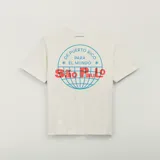 Camiseta Adidas Originals en colaboración con Bad Bunny, color blanco marfil, de manga corta y cuello redondo. Presenta un estampado gráfico en la espalda con un globo terráqueo en azul y las inscripciones "De Puerto Rico para el mundo" y "São Paulo" en rojo.