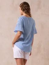 Blusa de mangas cortas amplias con aplique de botones en los hombros. Diseño a rayas verticales celestes y blancas.