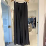 Pantalón gris oscuro de gasa plisada, de corte amplio y fluido con cintura elástica.