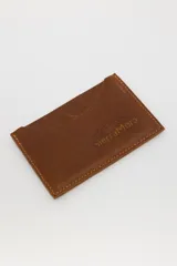 Tarjetero de cuero con diseño animal print en el frente y cuero liso marrón oscuro en la parte posterior, con compartimentos para tarjetas en ambos lados.