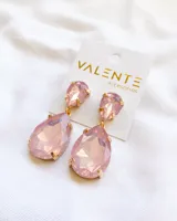 Aros colgantes con cristales rosados en forma de gota y engarce dorado.