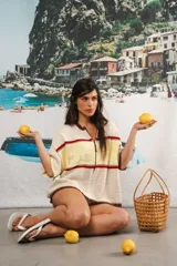 Remera de punto con diseño retro de bloques de color en marrón, crema y celeste. Presenta cierre frontal, cuello redondo, mangas cortas y tejido calado en la parte inferior. Incluye detalle de logo en relieve en el frente.