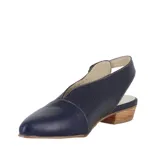 Zapato de cuero color crema, con punta fina, escote en V y laterales calados. Tiene talón descubierto, taco bajo foliado y suela de goma antideslizante.