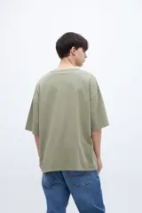 Remera verde oliva teñida en prenda con bolsillo en el pecho, de algodón lavado con textura extra suave y calce boxy.