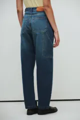 Pantalón de jeans azul oscuro, de tiro medio y corte holgado, estilo carpintero.