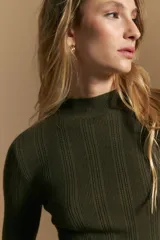 Polera de punto acanalado color gris, con cuello alto y mangas largas, de calce ajustado al cuerpo.