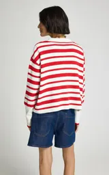 Sweater de punto Le Lis Blanc con diseño de rayas horizontales rojas y blancas, cuello polo con escote en V profundo, mangas largas de hombros caídos y puños acanalados.