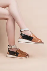 Sandalias de cuero vacuno con semi plataforma, diseño multicolor con frente texturizado y pintado a mano, talón negro y tira al tobillo en tono claro con hebilla metálica.