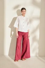Camisa de lino color fucsia, con cuello mao, mangas cortas holgadas y cierre frontal con botones de madera. Cuenta con bolsillos frontales en el pecho.