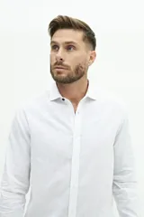 Camisa de manga larga color beige claro, confeccionada en una mezcla de lino y algodón. Presenta un corte semi slim, cuello camisero y un pequeño logo bordado en el pecho.