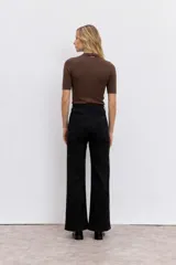 Blusa de punto color negro, con cuello alto y mangas cortas ajustadas.