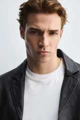 Blazer de corte relajado confeccionado en piel genuina, con cuello de solapas de muesca, manga larga y cierre frontal de tres botones. Presenta bolsillos de vivo en la cadera y un bolsillo interior.