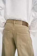 Jeans de tiro alto con pinzas delanteras, pernera ancha y fluida. Cuenta con cierre frontal de cremallera y botón, bolsillos frontales y bolsillos de plastrón en la parte trasera.