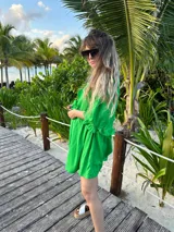 Vestido corto verde manzana de lino, con escote en V con volados y mangas abullonadas.