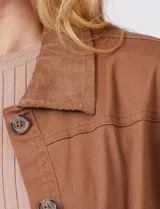 Sobrecamisa color marrón con cuello solapa de pana y cierre frontal con botones. Presenta bolsillos en la parte delantera.
