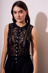 Blusa negra sin mangas de encaje con botones frontales.