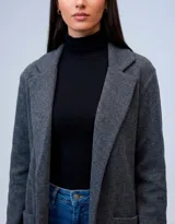 Blazer de tejido de algodón soft con cuello solapa, abertura central y bolsillos delanteros.